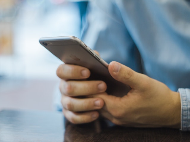 Person håller i en mobiltelefon